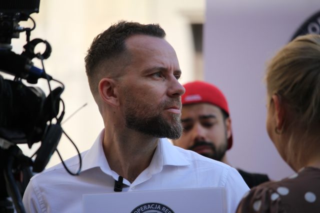 Maciej Wilk udziela wywiadu dziennikarce przed kamerą