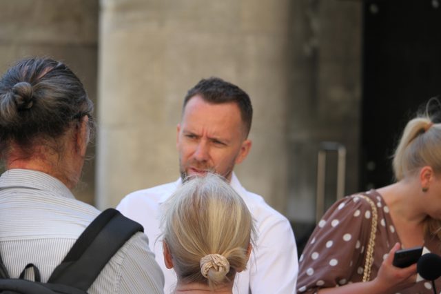 Maciej Wilk rozmawia z grupą warszawiaków
